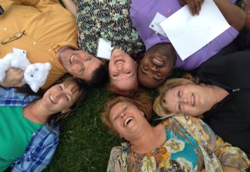 Employees having fun lying in the grass