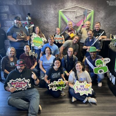 Group celebrating success after completing an escape room challenge during their Mystery Bus team building event. thumbnail