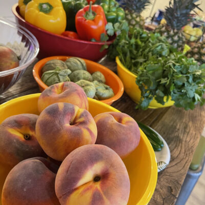 Fresh peaches, bell peppers, pineapples, and cilantro displayed at a Salsa Showdown, ready to be transformed into flavorful salsa creations. thumbnail