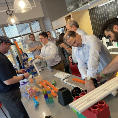Participants at the Domino Effect team building event working together to complete a building challenge. thumbnail
