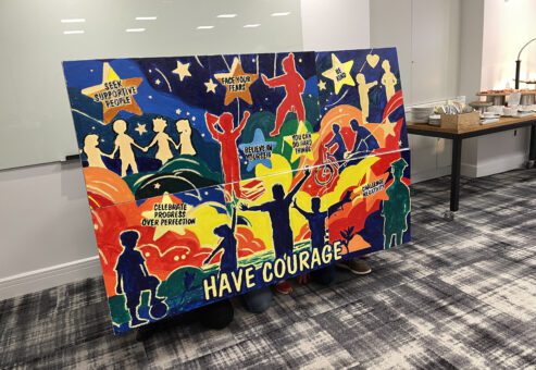 A vibrant mural created during The Big Picture team building event, featuring inspiring messages such as 