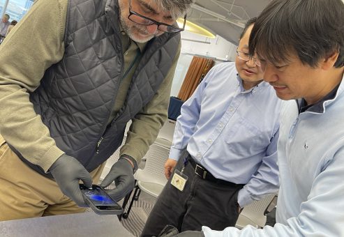Participants using UV light to inspect a crime scene map during the Corporate CSI team building event..