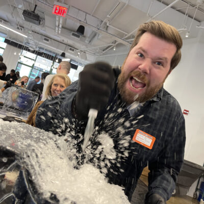 A participant energetically carves into an ice block during a Team building Ice Sculpting event, demonstrating focus and collaboration. thumbnail