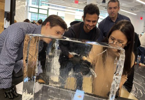 Participants focused on sculpting a block of ice during a Team building Ice Sculpting event, collaborating to create impressive works of art.