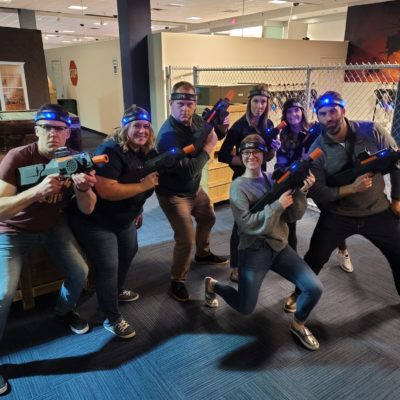 Team gearing up for a thrilling laser tag battle during a Mystery Bus team building event, fostering camaraderie through fun and active competition. thumbnail