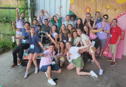 Group photo of a team full of energy and excitement during a Mystery Bus team building event, posing together for a fun and memorable moment.