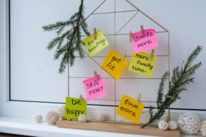 A decorative display with colorful sticky notes featuring motivational phrases, surrounded by greenery and decorative orbs.